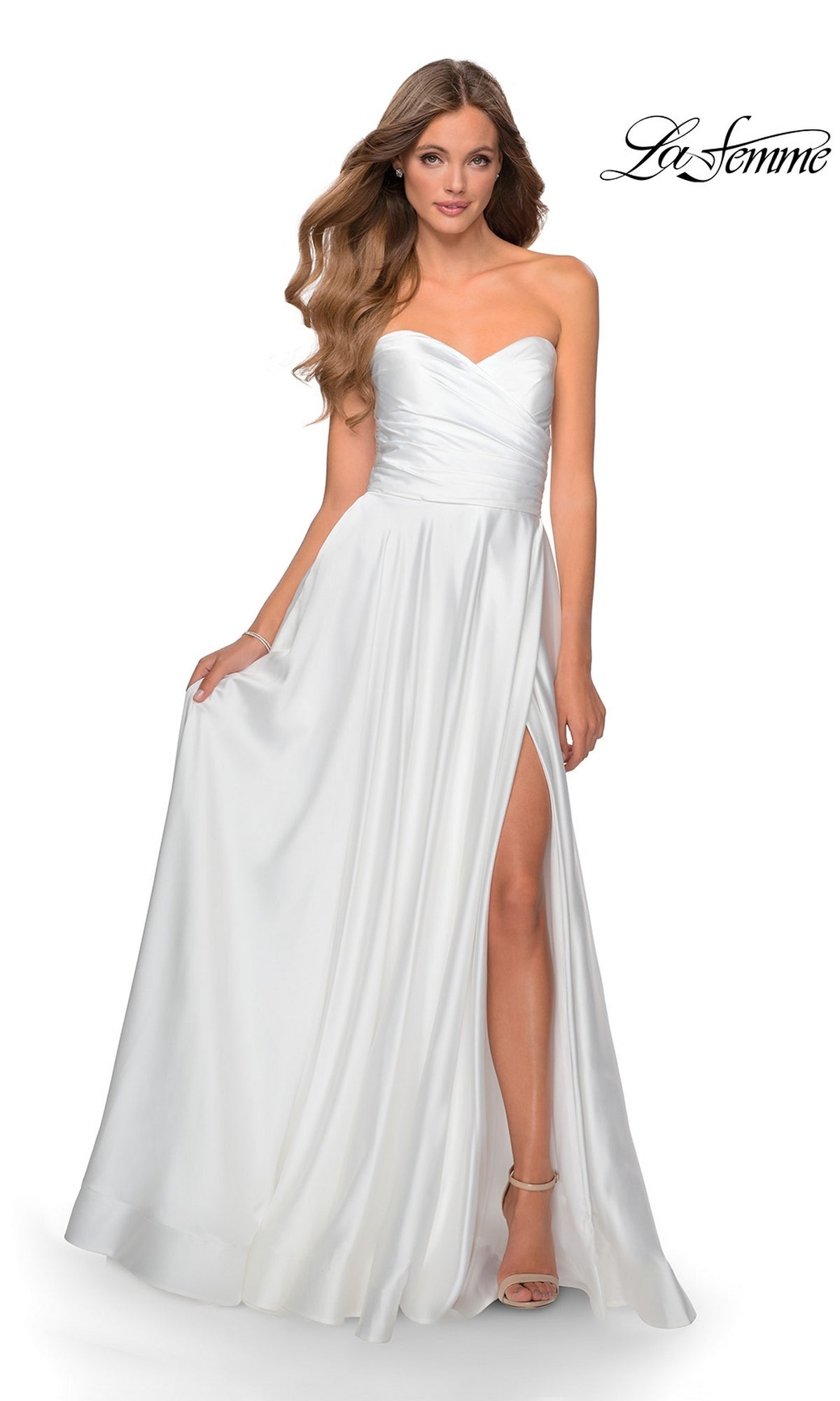 Woman modeling the La Femme Strapless Long A-Line Prom Dress 28608 with a sweetheart neckline and thigh-high slit, holding the skirt;